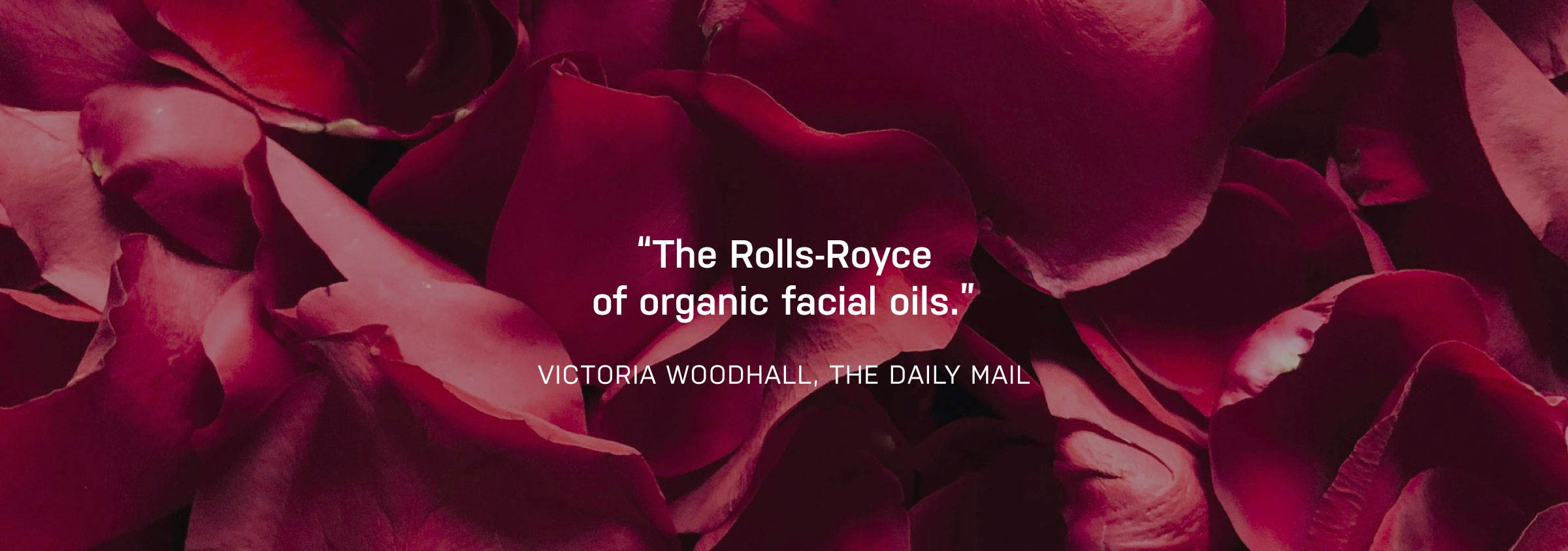 Red rose petals with a quote praising an organic facial oil brand.